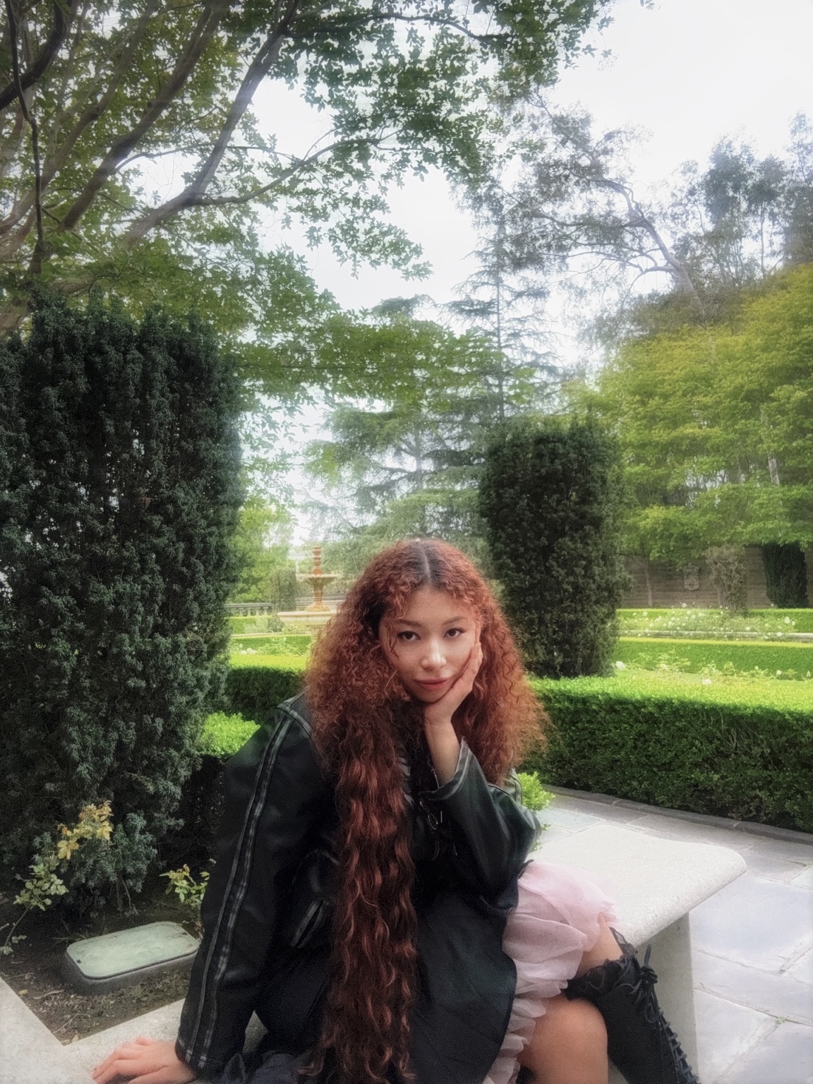 Mboni Lux seated in a garden